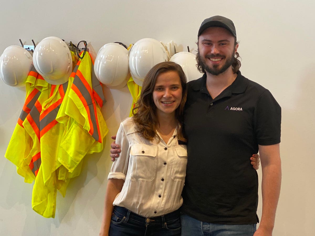 Maria Davidson and Ryan Gibson standing together among hard hats and high-visibility vests