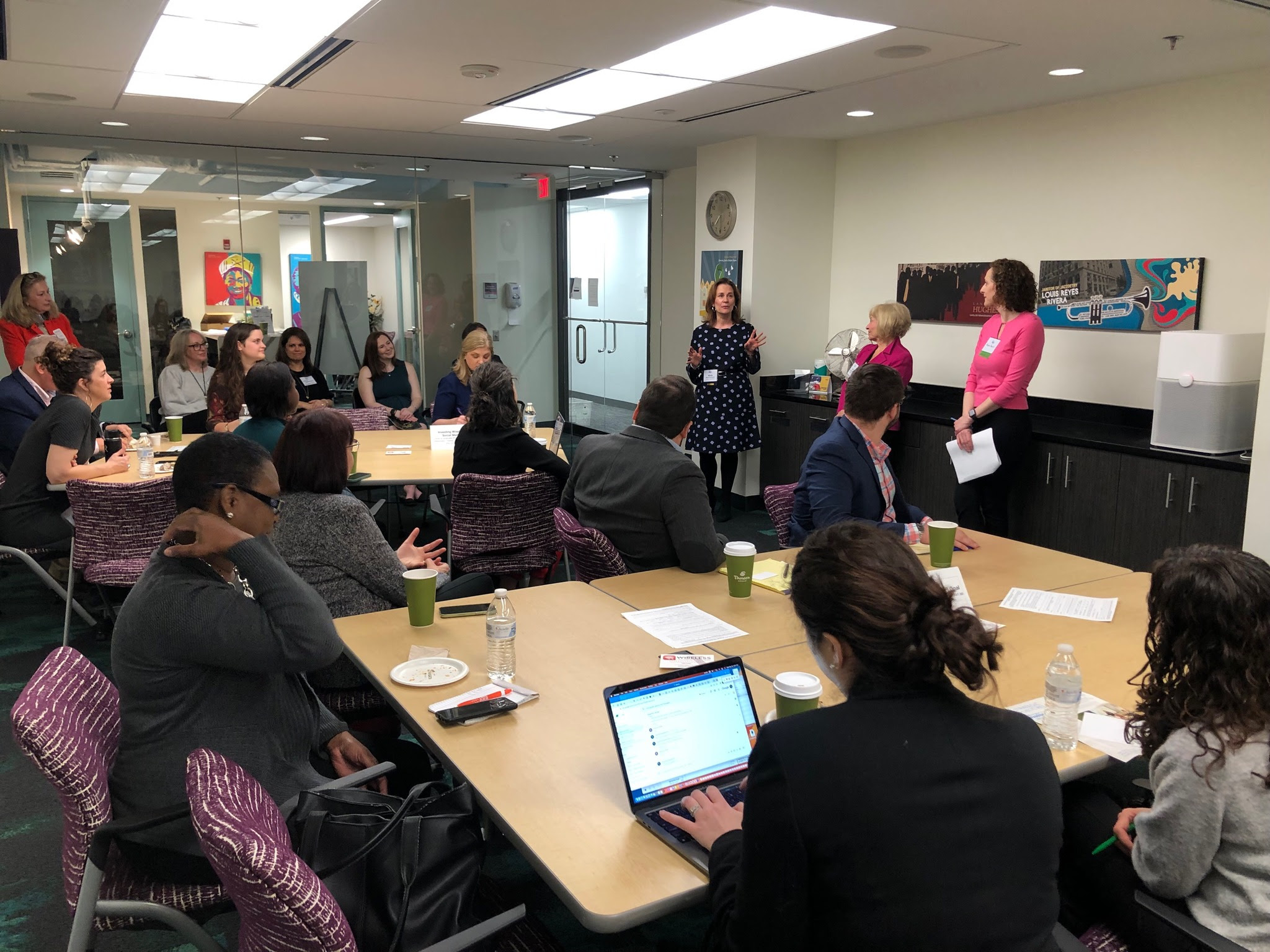 Maria Rodriguez speaking to a group gathered around tables at Vanguard’s Washington office