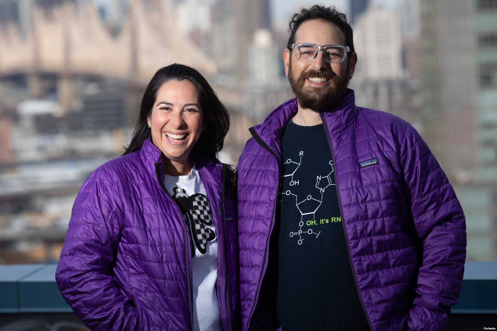 Maria Luisa Pineda, left, with co-founder Martin Akerman, both wearing purple jackets outdoors in New York