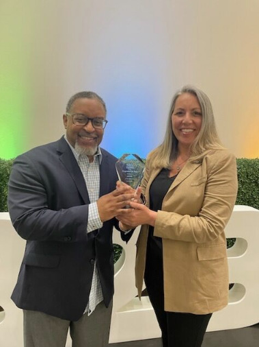 Maria Robinson and Michael Brown holding Reltio's Program of the Year award at the 2023 Forrester B2B Summit