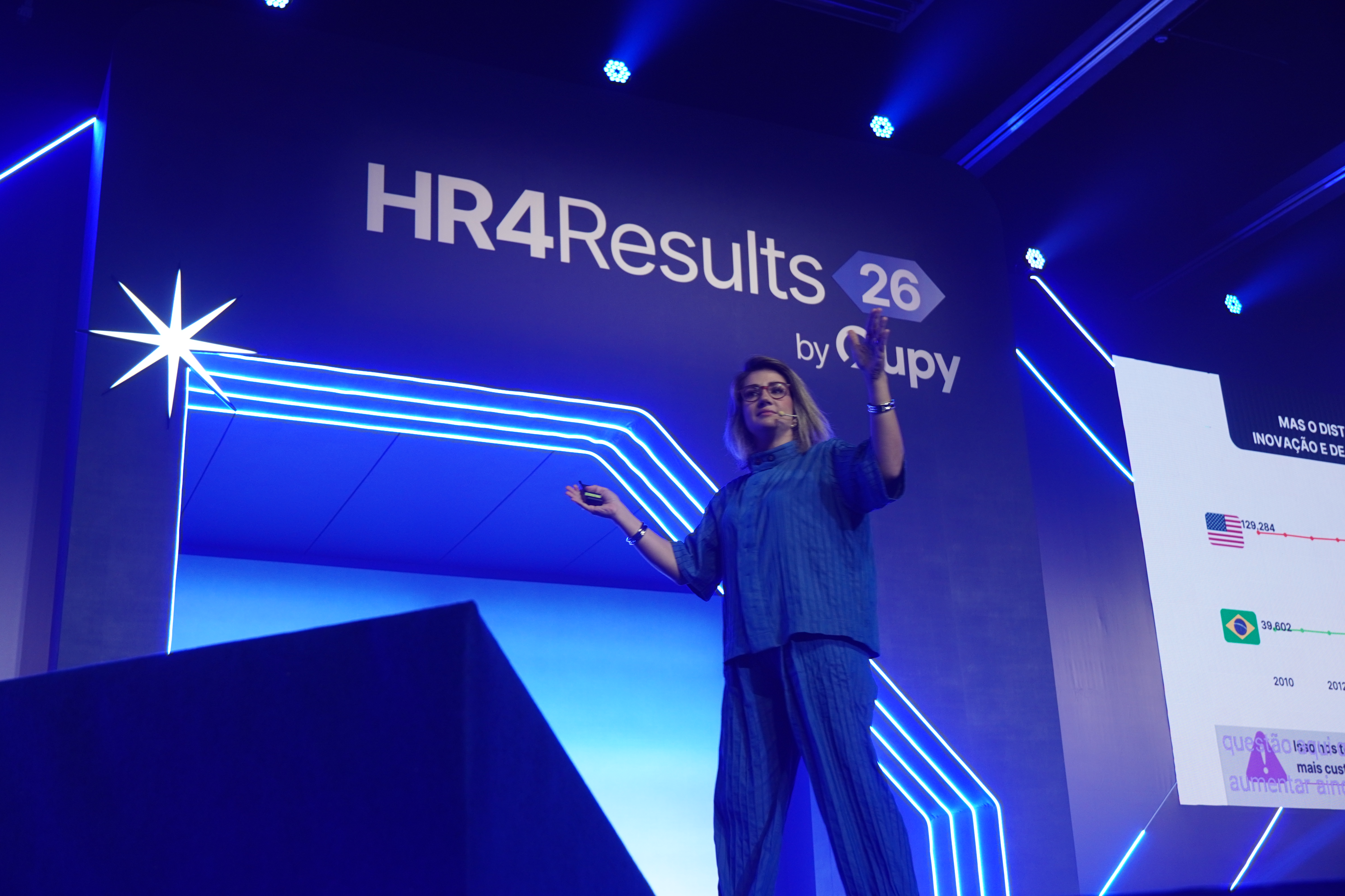 Mariana Dias speaking on the blue-lit HR4Results 2026 stage in São Paulo