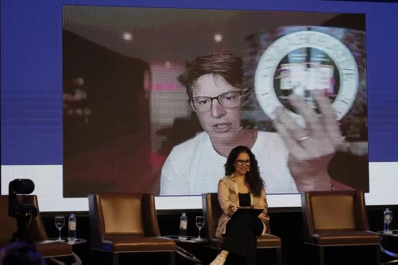 Mariano Suarez-Battan joins the Forbes Argentina Future of Work Summit remotely on a large screen, with interviewer Florencia Radici seated onstage.
