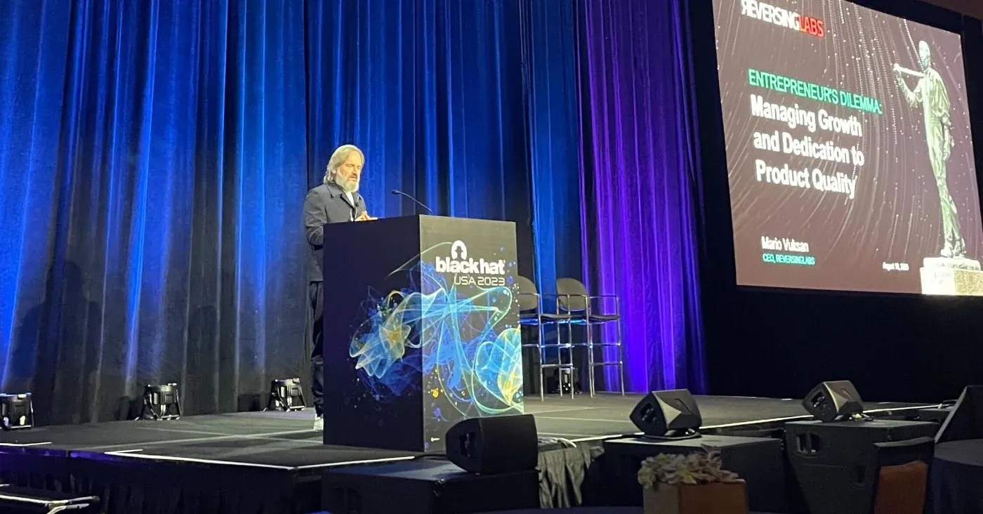 Mario Vuksan speaking at a podium at Black Hat in 2023