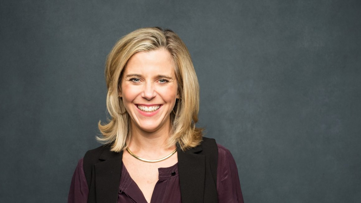 Marion Crawford smiling against a charcoal studio background