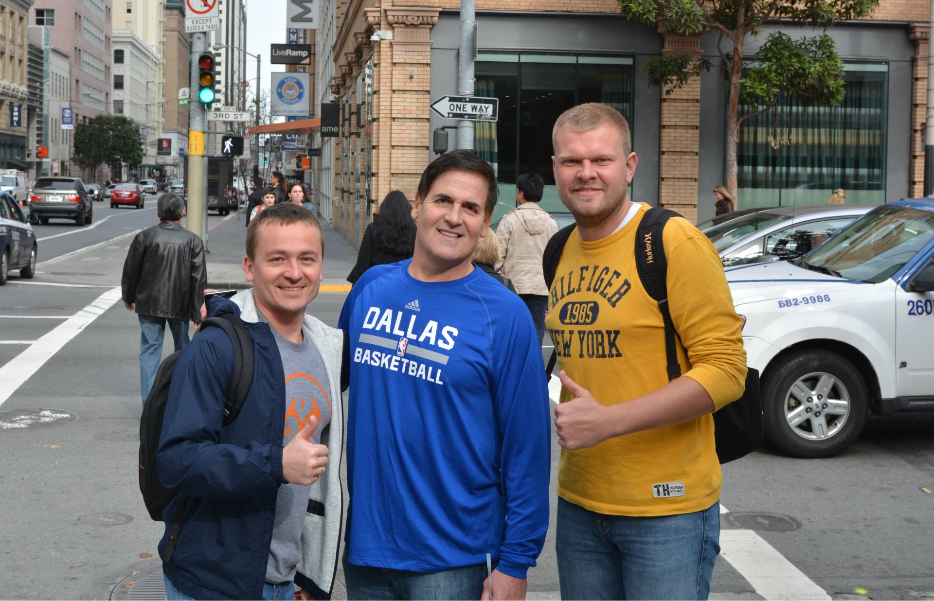 Mariusz Cieply, Mark Cuban and Szymon Klimczak standing together on a city pavement