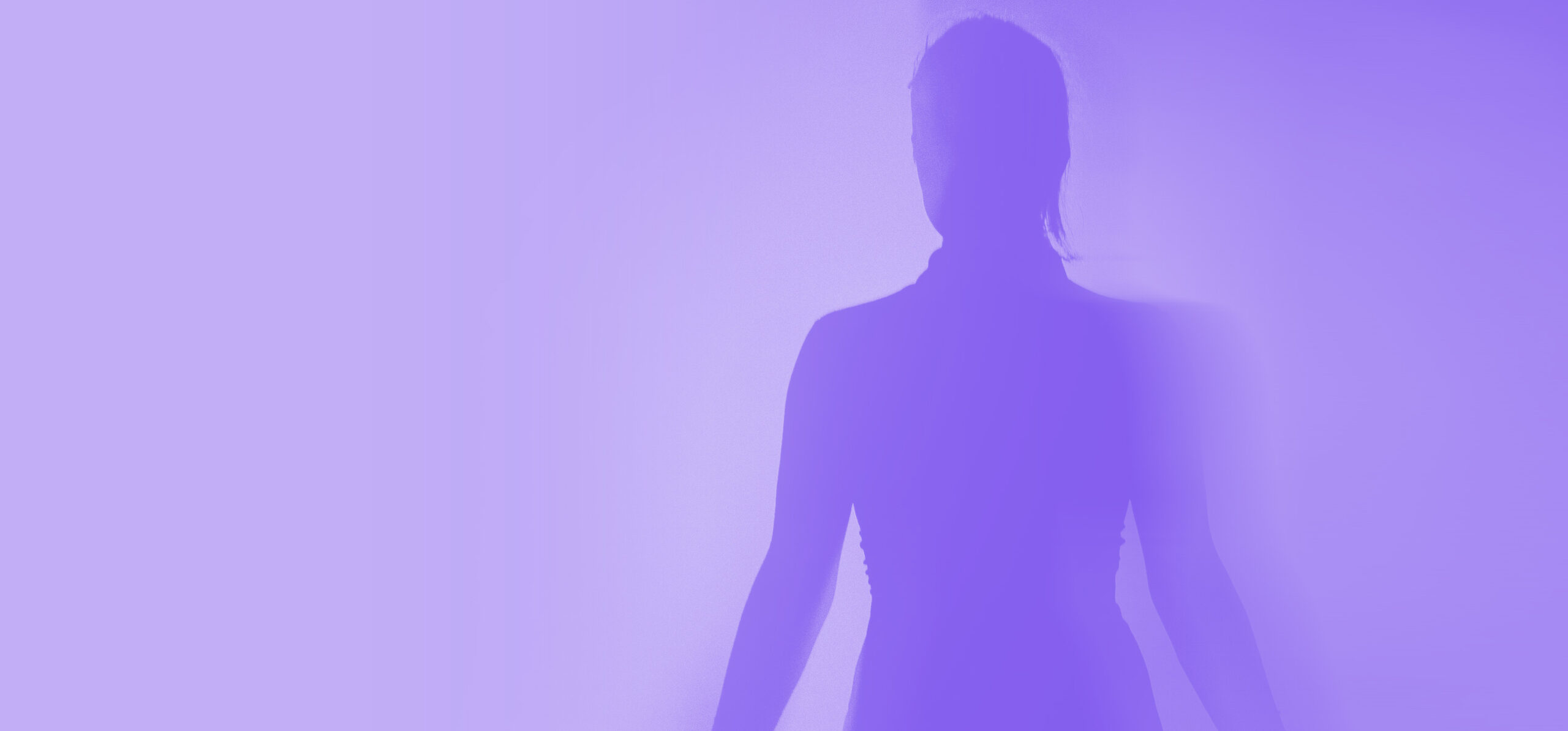 A speaker's silhouette emerges through purple stage light