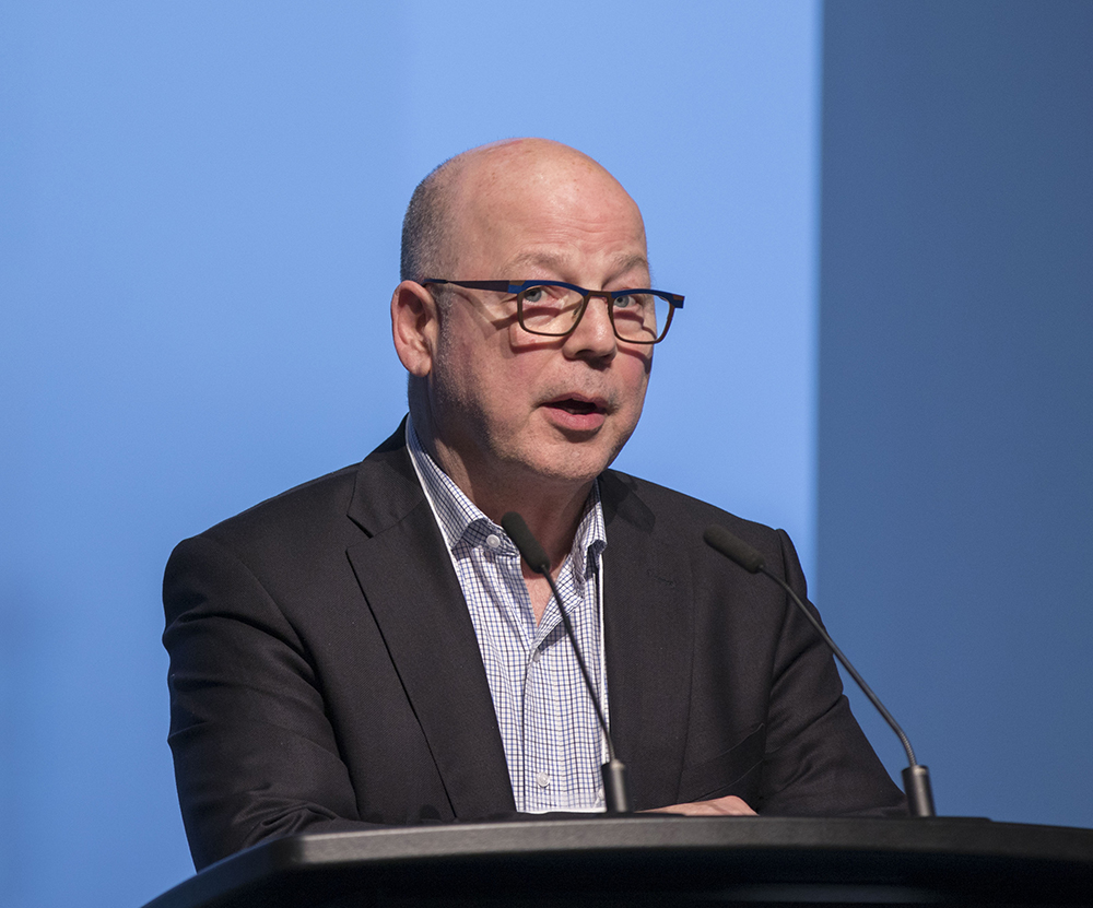 Mark Childs speaking onstage during a marketing industry event