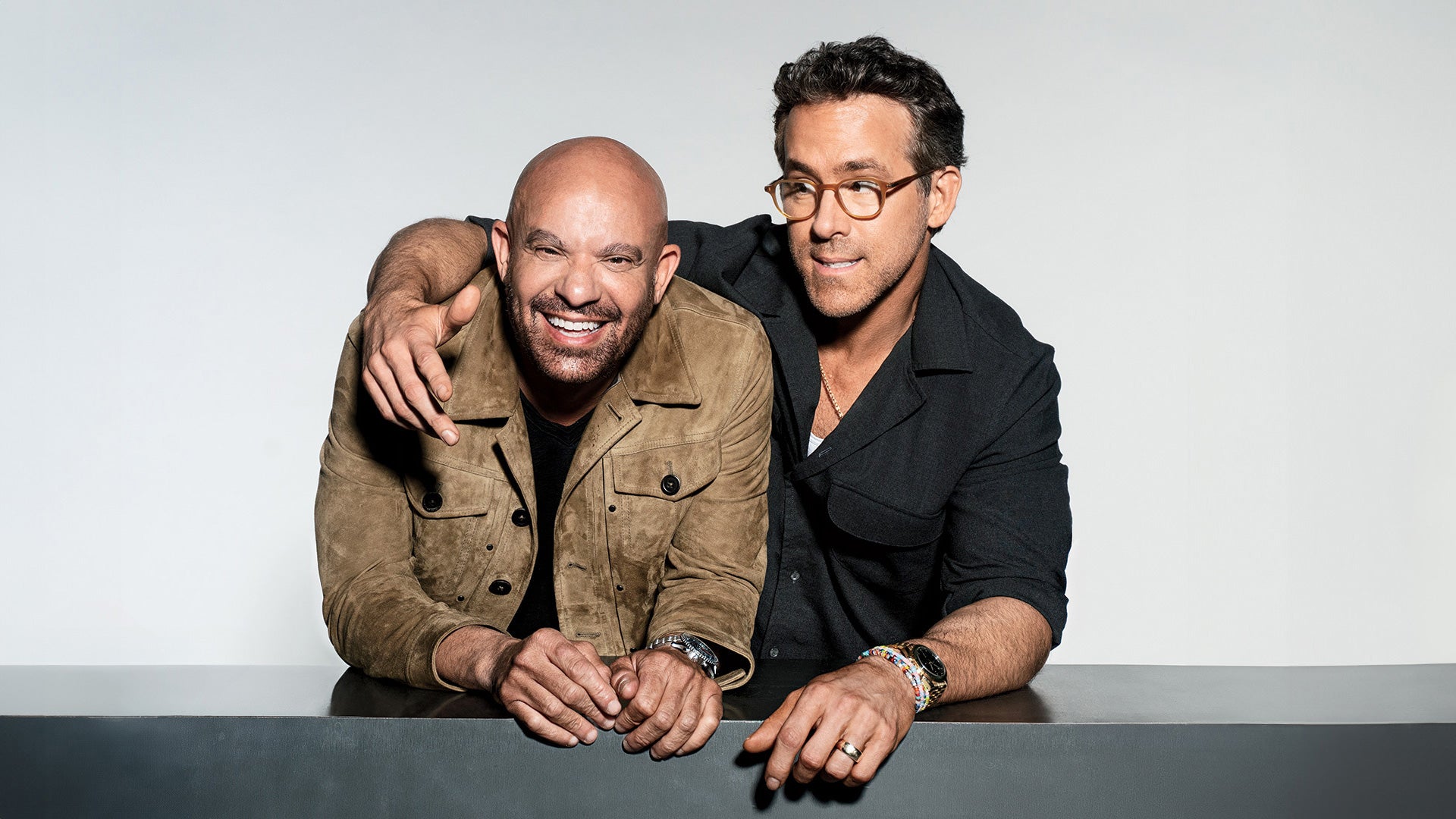 Mark Douglas, left, and Ryan Reynolds leaning together on a ledge during an Inc. photo shoot