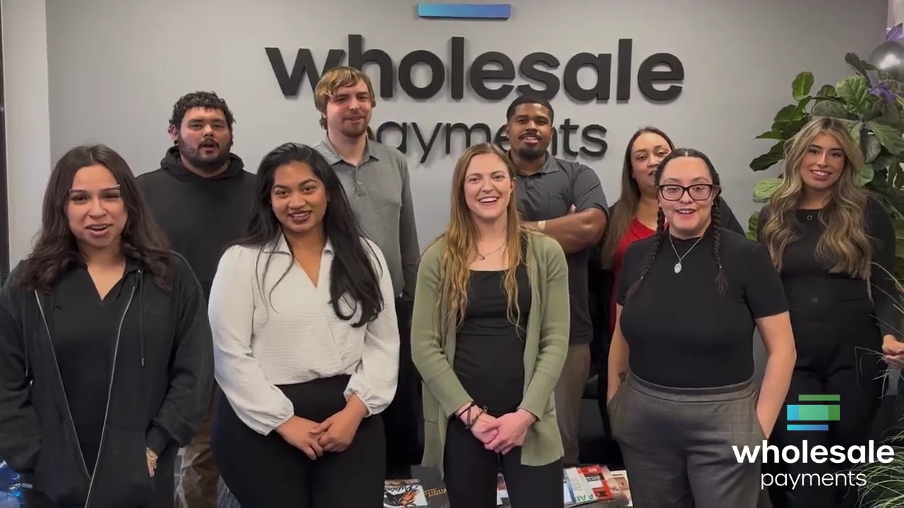 Wholesale Payments colleagues together in an office during their birthday tribute video for Mark Hodges