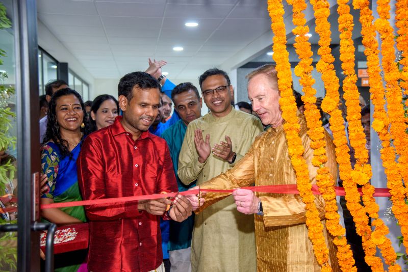 Mark Hussey, wearing gold, cuts a red ribbon with Huron colleagues at the Chennai office opening.