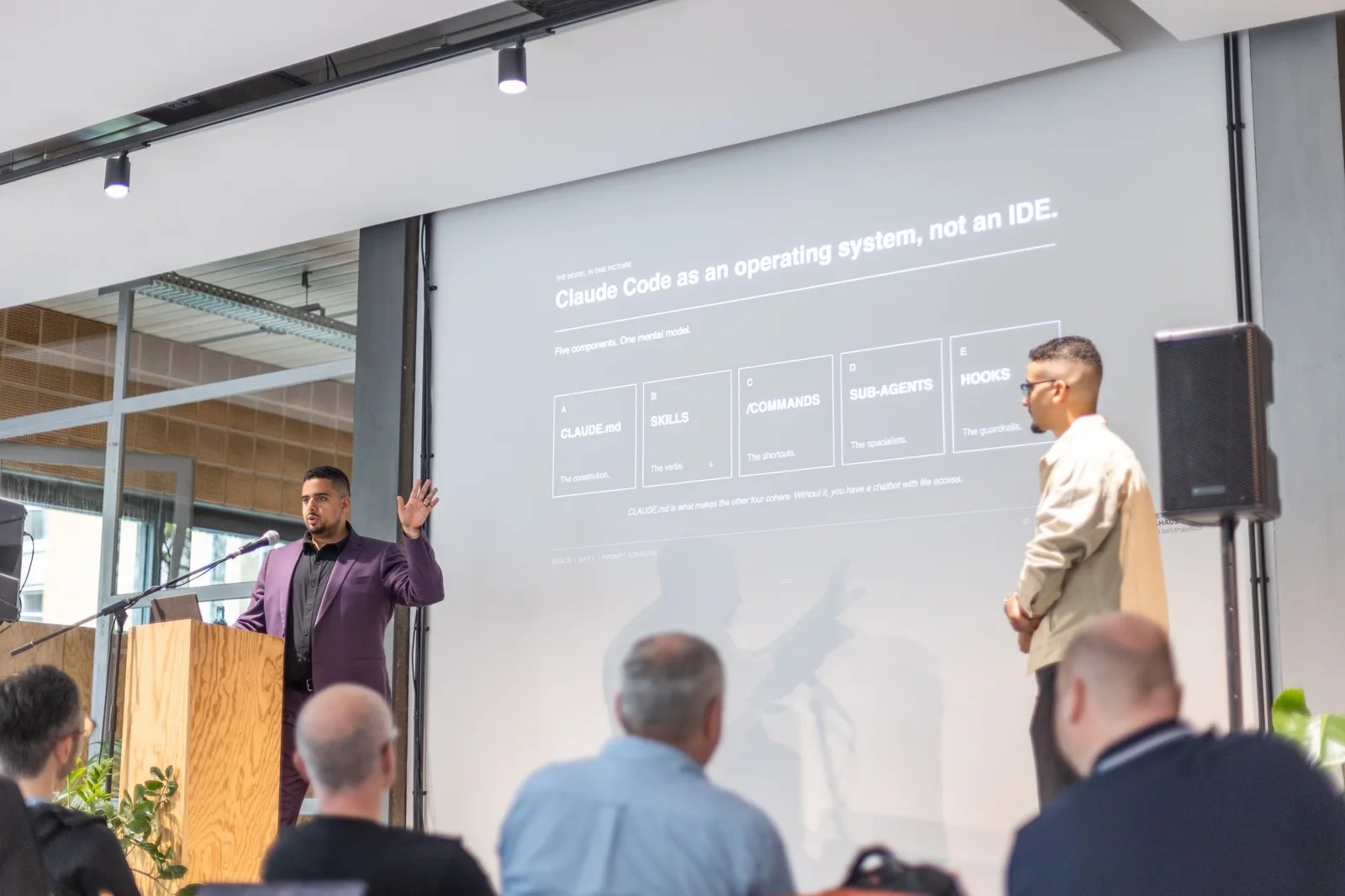 Mark Kashef speaking on stage with Taha El Harti at an Early AI-dopters event in Berlin