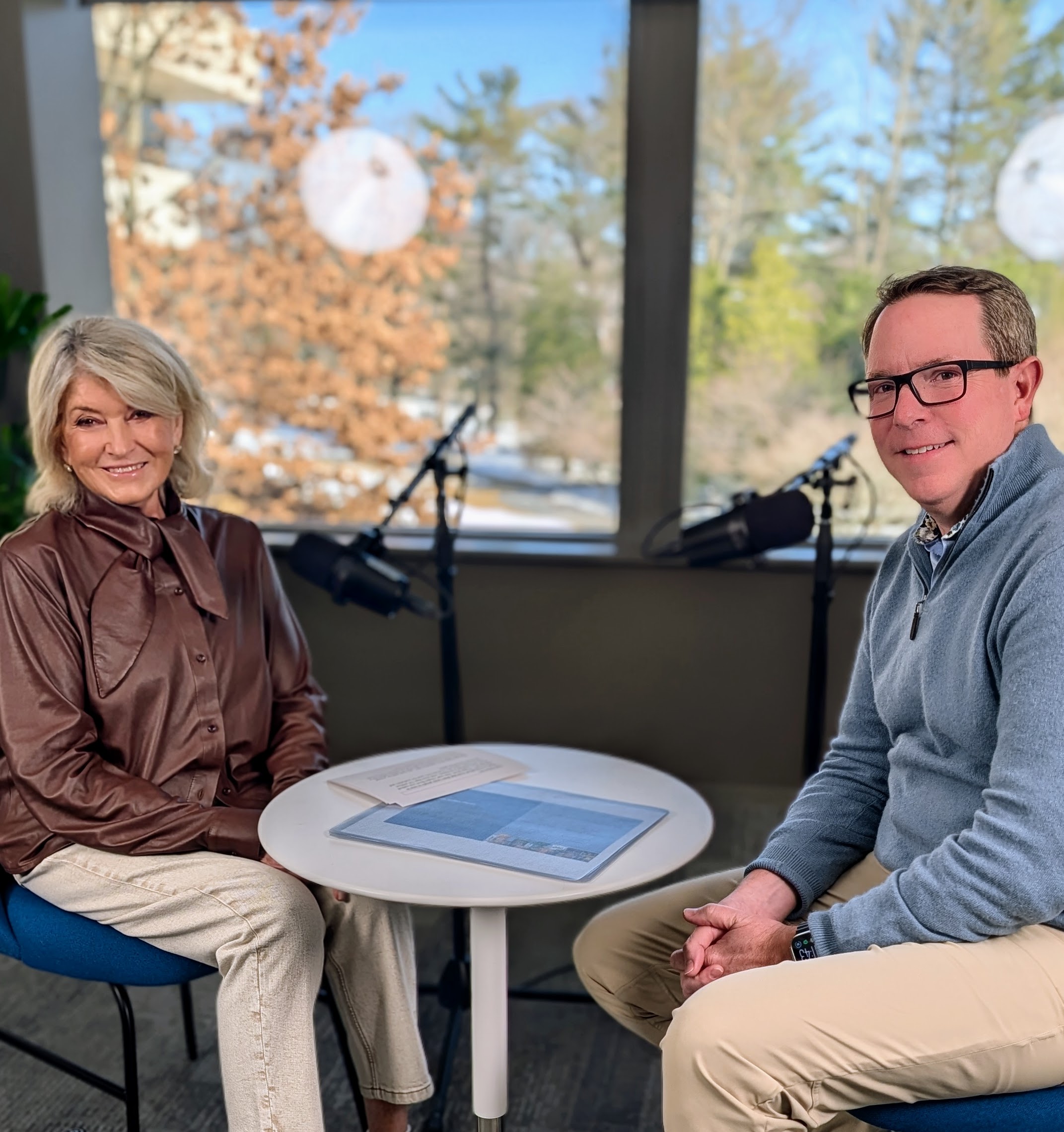 Martha Stewart and Mark Kirkham seated at microphones during a podcast recording at PepsiCo headquarters
