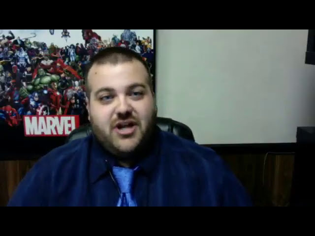 Mark Luckenbaugh speaking from his office during the 2017 SEO debate, with a Marvel poster behind him.