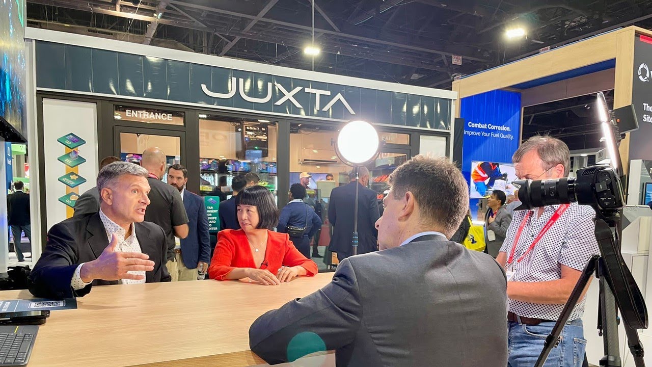 Mark Morelli, left, in conversation with Carol Chen at NACS 2023 while a camera records