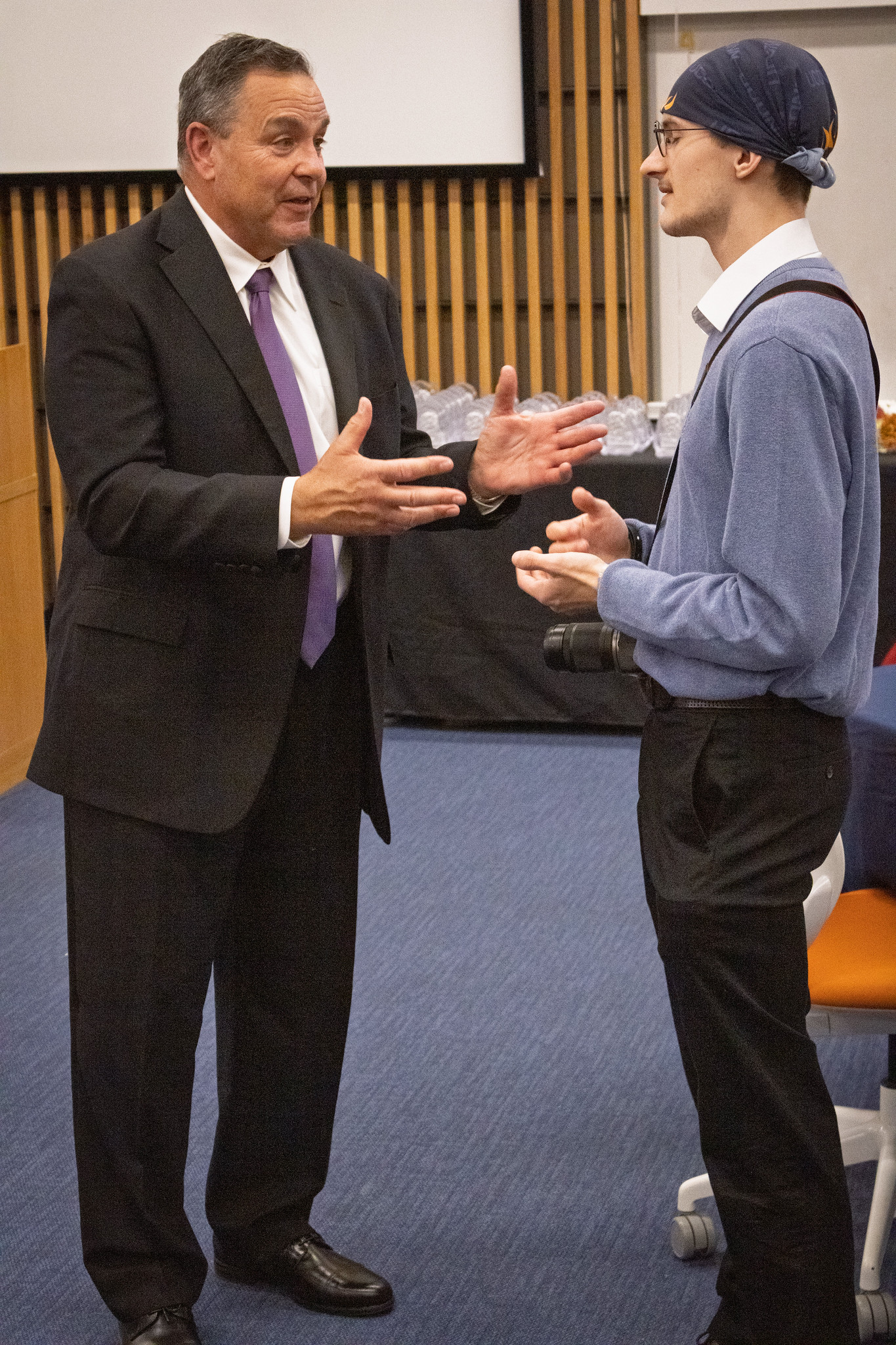 Mark Vergnano speaking with a student at UConn’s April 2026 institute showcase