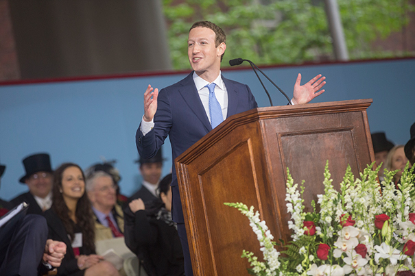 Mark Zuckerberg speaking at a wooden lectern during Harvard’s 2017 Commencement, with seated guests behind him