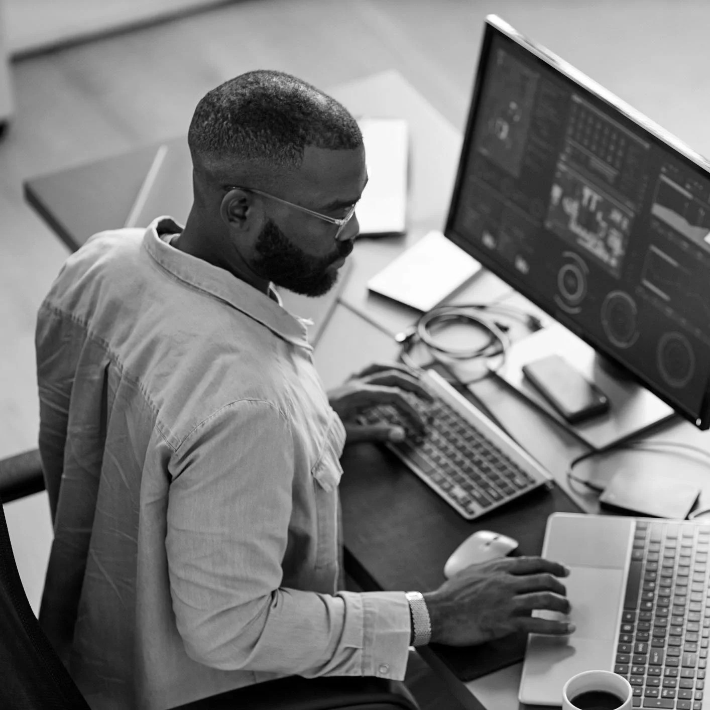 A web professional working at a desk with two monitors
