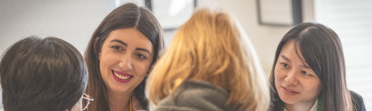 People in conversation in a photograph from MarketOne’s careers page
