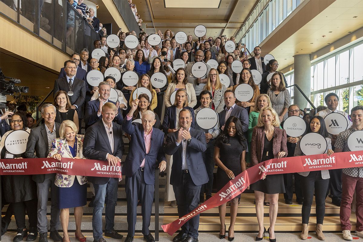 Marriott leaders and associates holding hotel-brand signs at the Bethesda headquarters ribbon cutting in September 2022