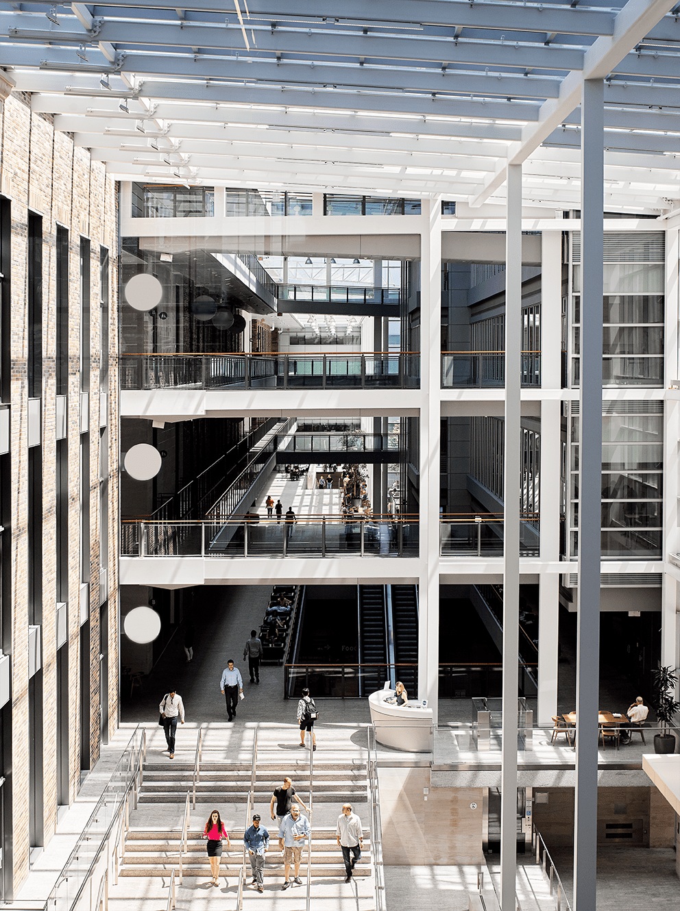 Glass-roofed MaRS atrium with heritage brickwork and modern walkways