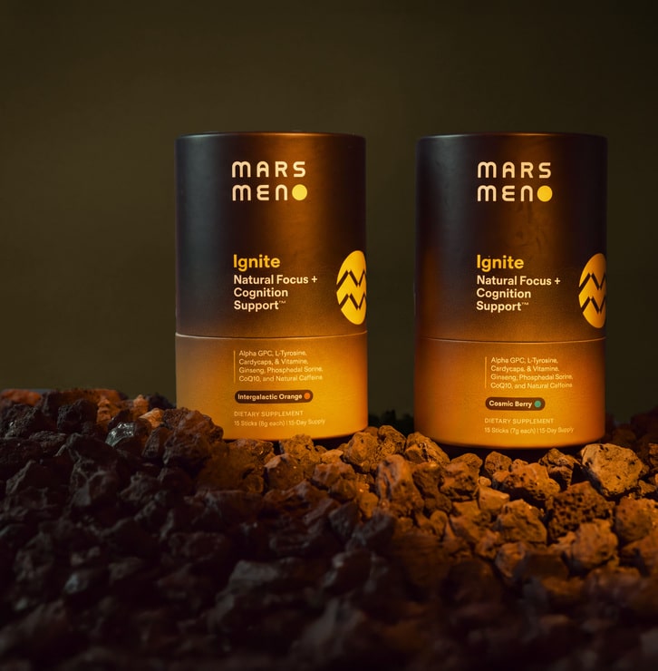 Orange and berry Mars Men Ignite packages displayed on a rocky set