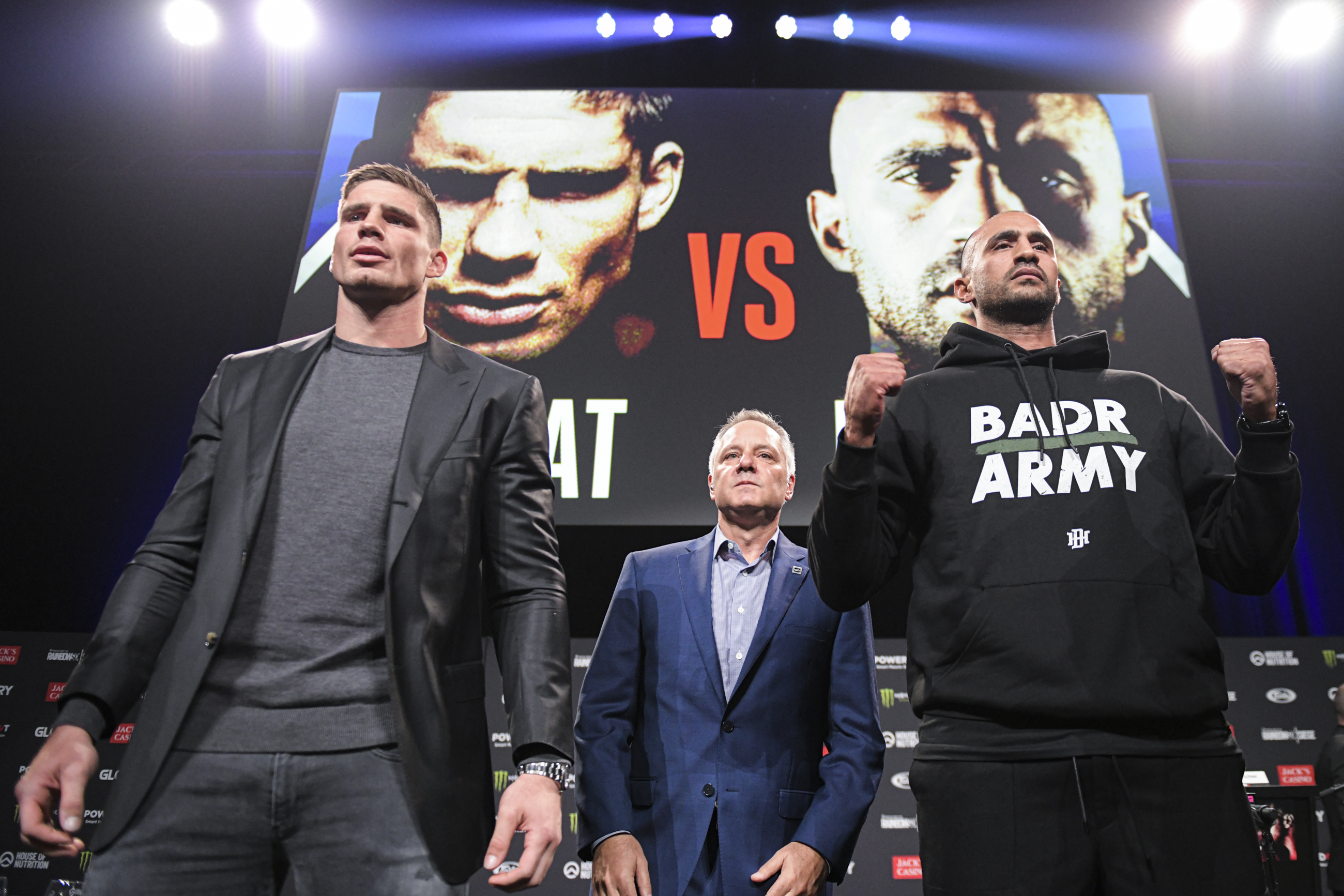 Marshall Zelaznik stands between kickboxers Rico Verhoeven and Badr Hari at the GLORY COLLISION 2 press conference