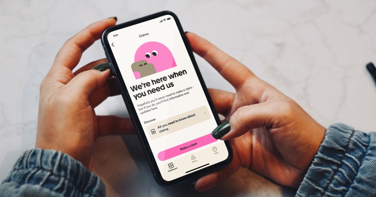 A customer holding a phone displaying the Marshmallow insurance app