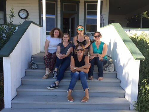 Five members of The Key team seated together on farmhouse steps at their Livermore offsite