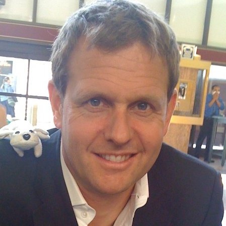 Martin Hitch smiling with a small soft toy perched on his shoulder