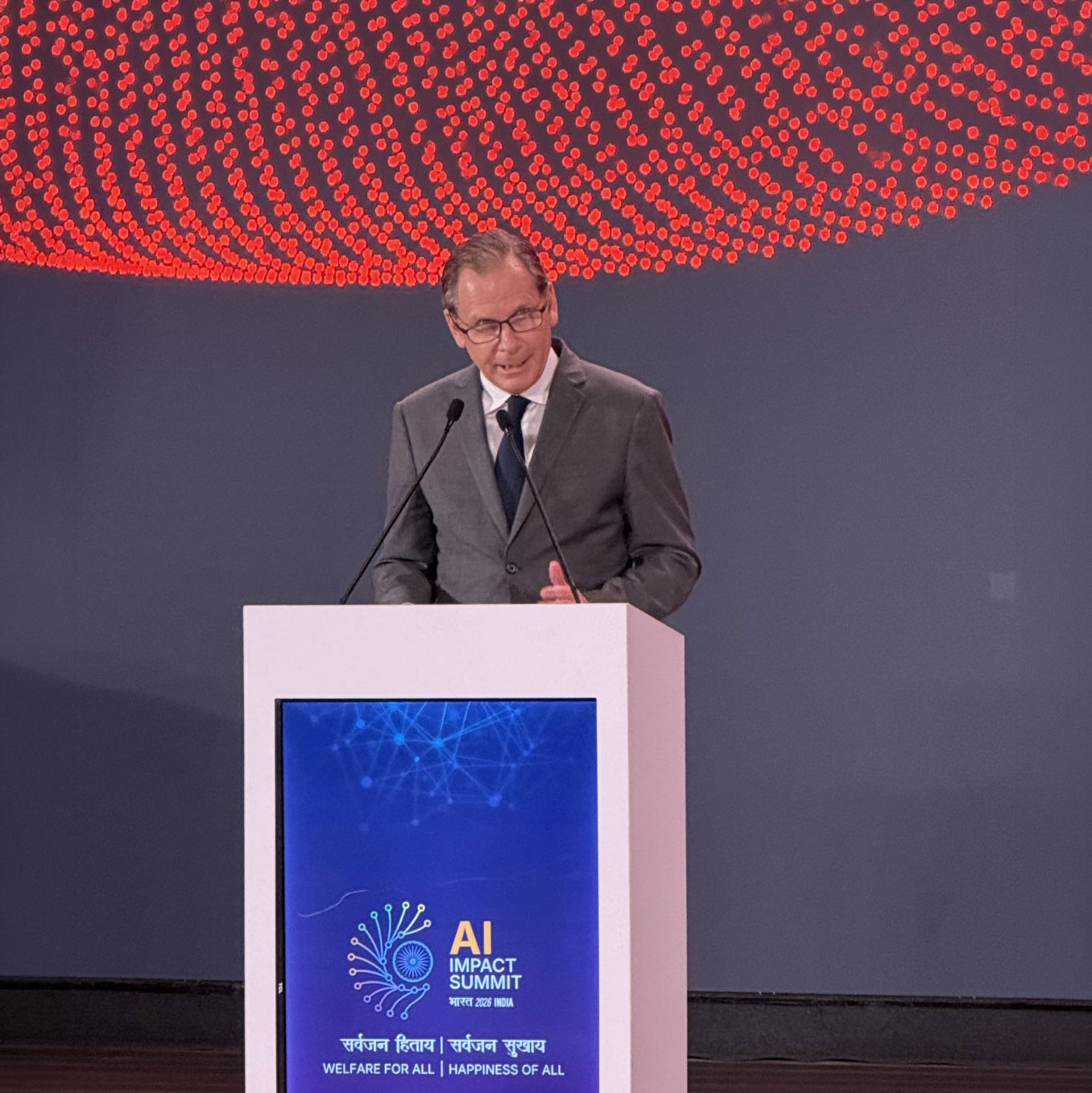 Martin Schroeter speaking at a lectern at the India AI Impact Summit in February 2026