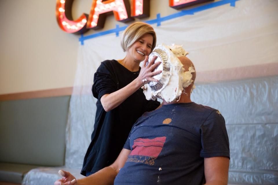 Julie Iskow presses a charity-event pie into Marty Vanderploeg's face