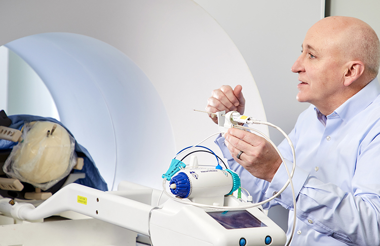 Marty Emerson standing beside the NeuroBlate system during a demonstration