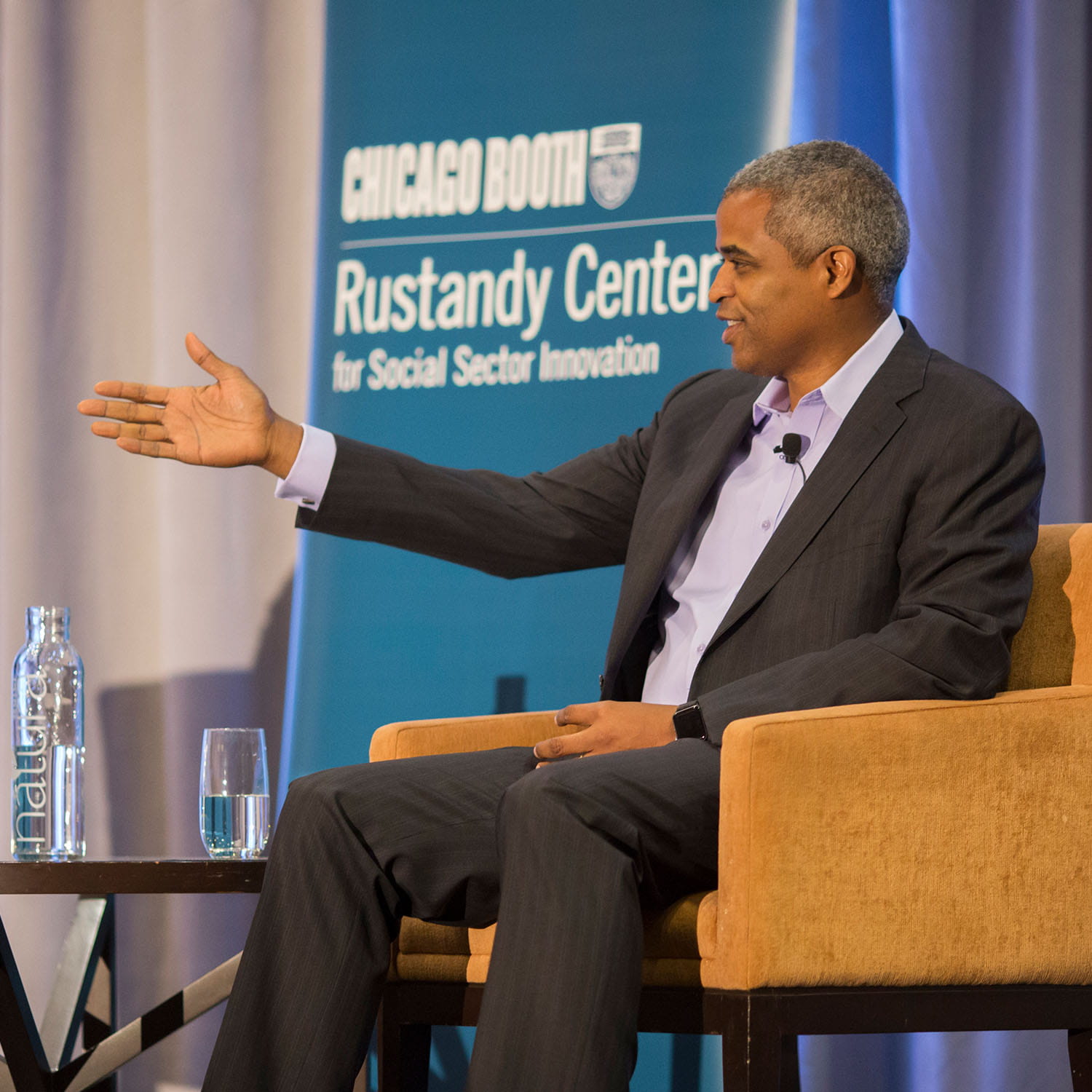 Marty Nesbitt speaking from an armchair at Chicago Booth’s Rustandy Center event