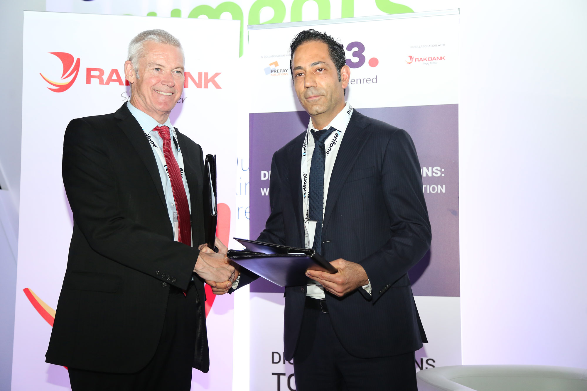 Peter England and Marwan Hachem holding agreement folders at the C3-RAKBANK signing