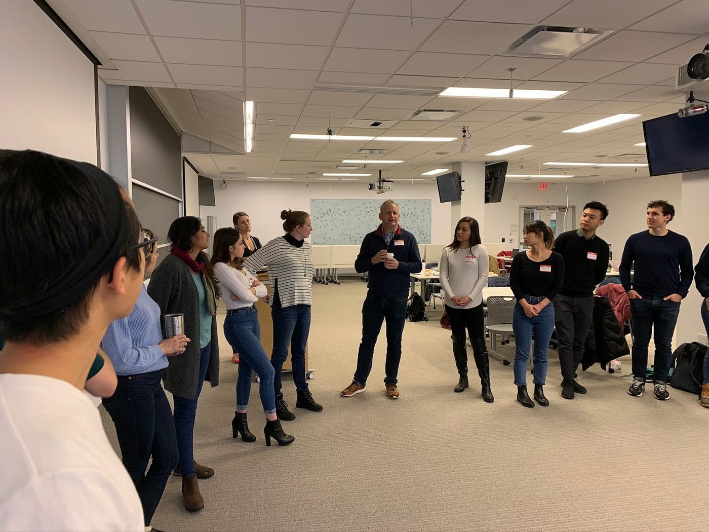 Mary Ann Brody, in a striped top, listens with students standing in a circle during a Harvard class exercise.