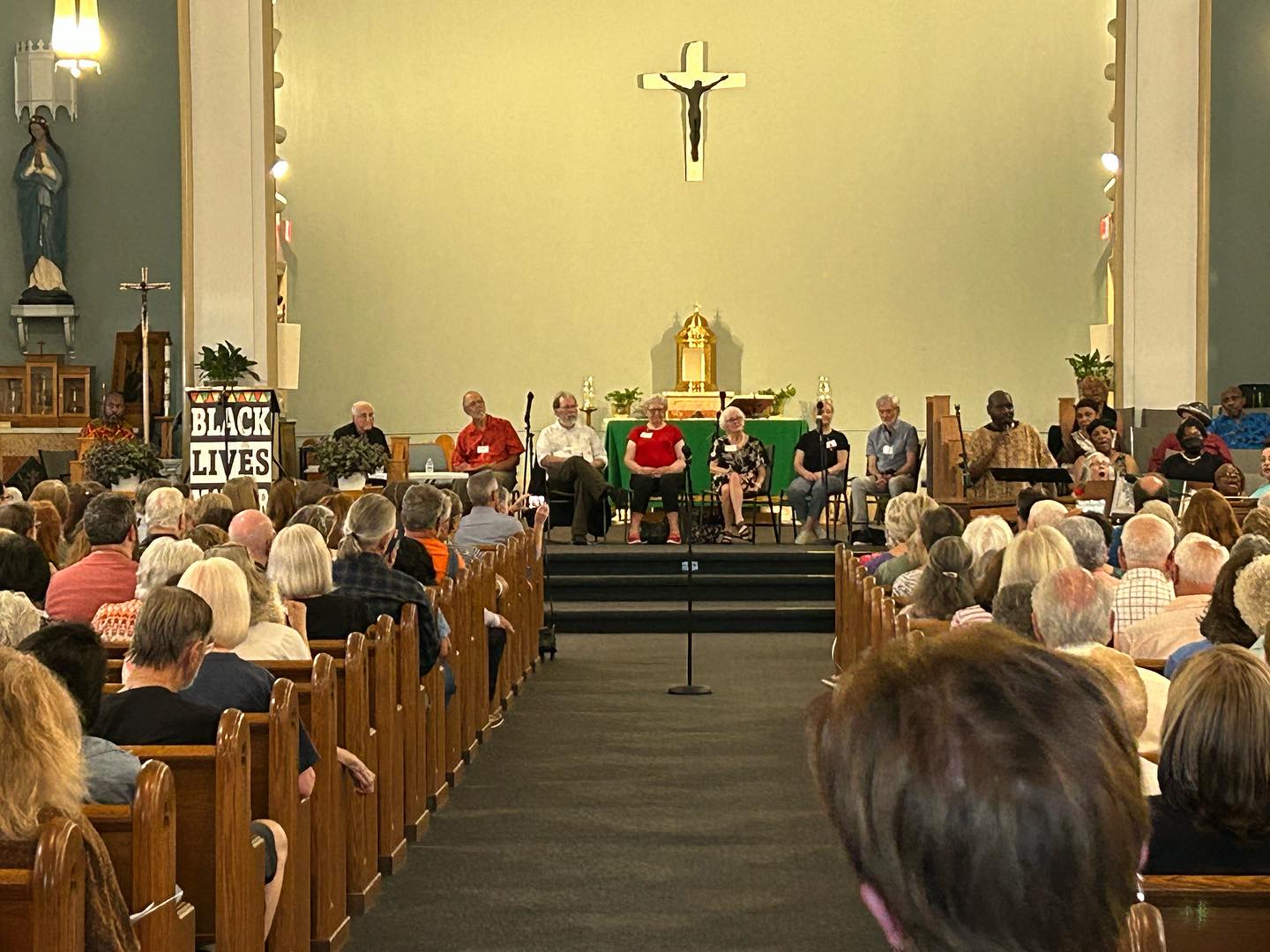 Speakers and choir face the audience at the No Guilty Bystander book launch at Sacred Heart Church in Detroit.