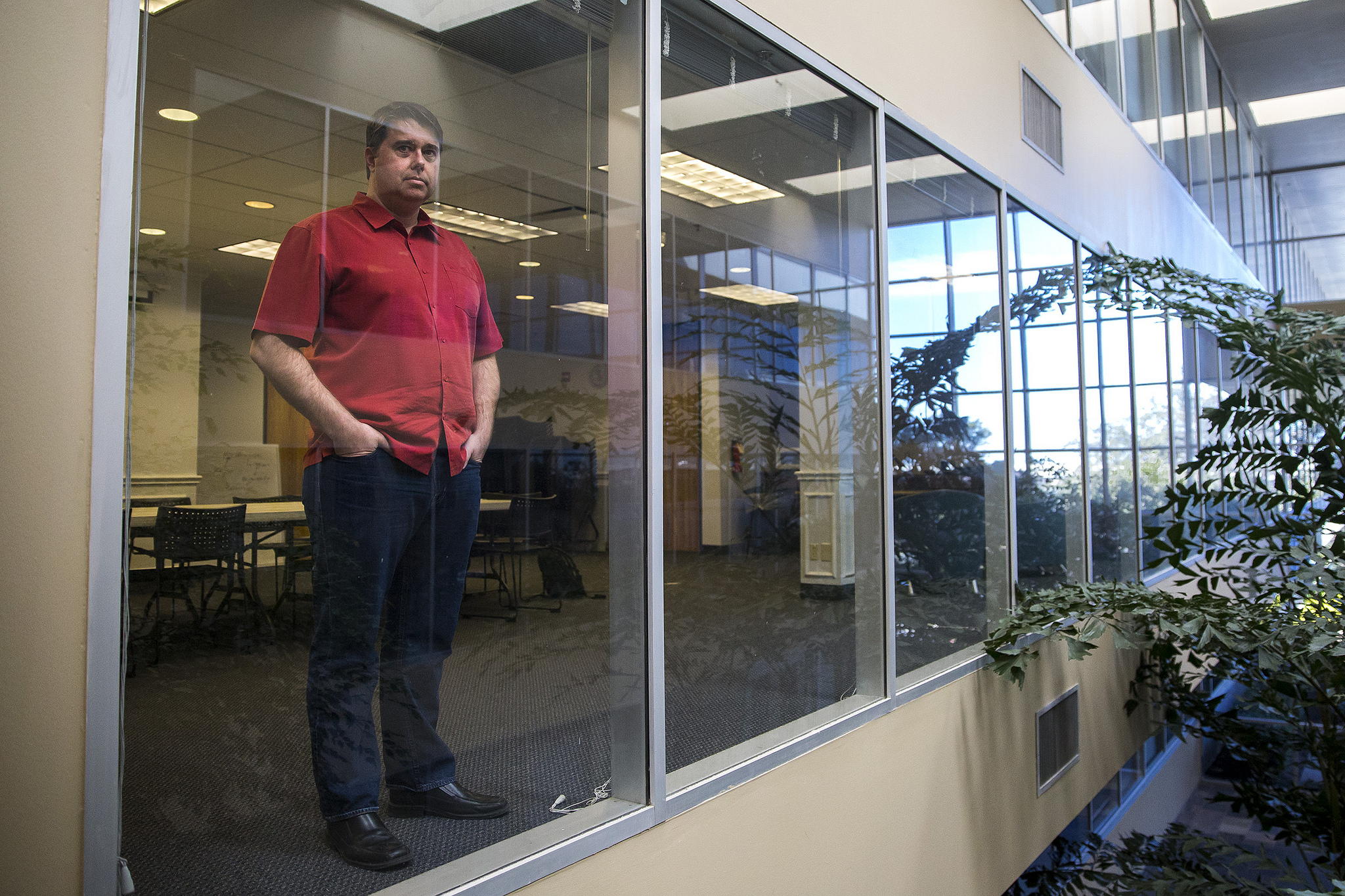 Mason Hale standing beside the glass wall of an Austin office