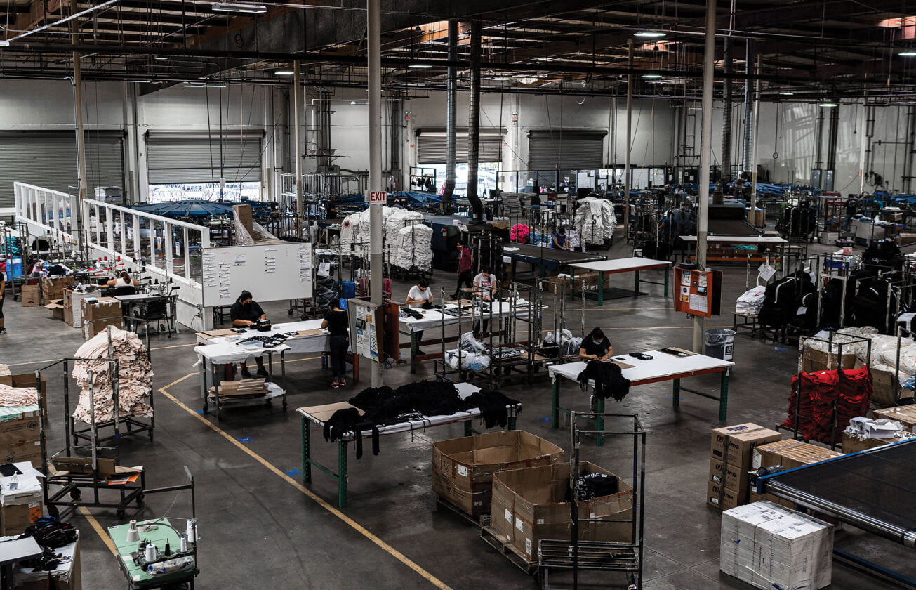 Workers and apparel production tables inside a Massive Prints facility