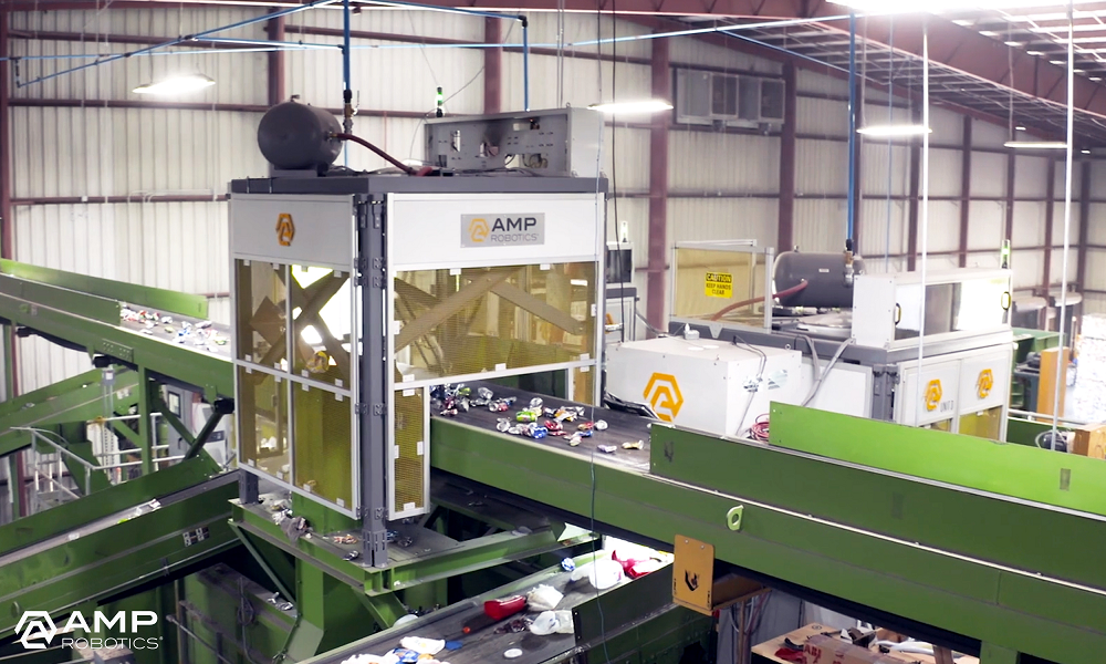 An AMP Cortex robotic sorting installation above a conveyor carrying recyclable material