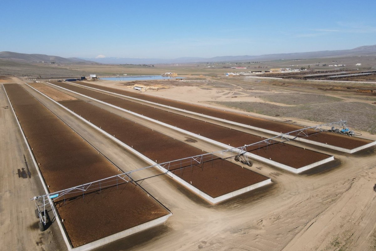 Long rectangular BioFiltro treatment beds with irrigation equipment at an agricultural installation