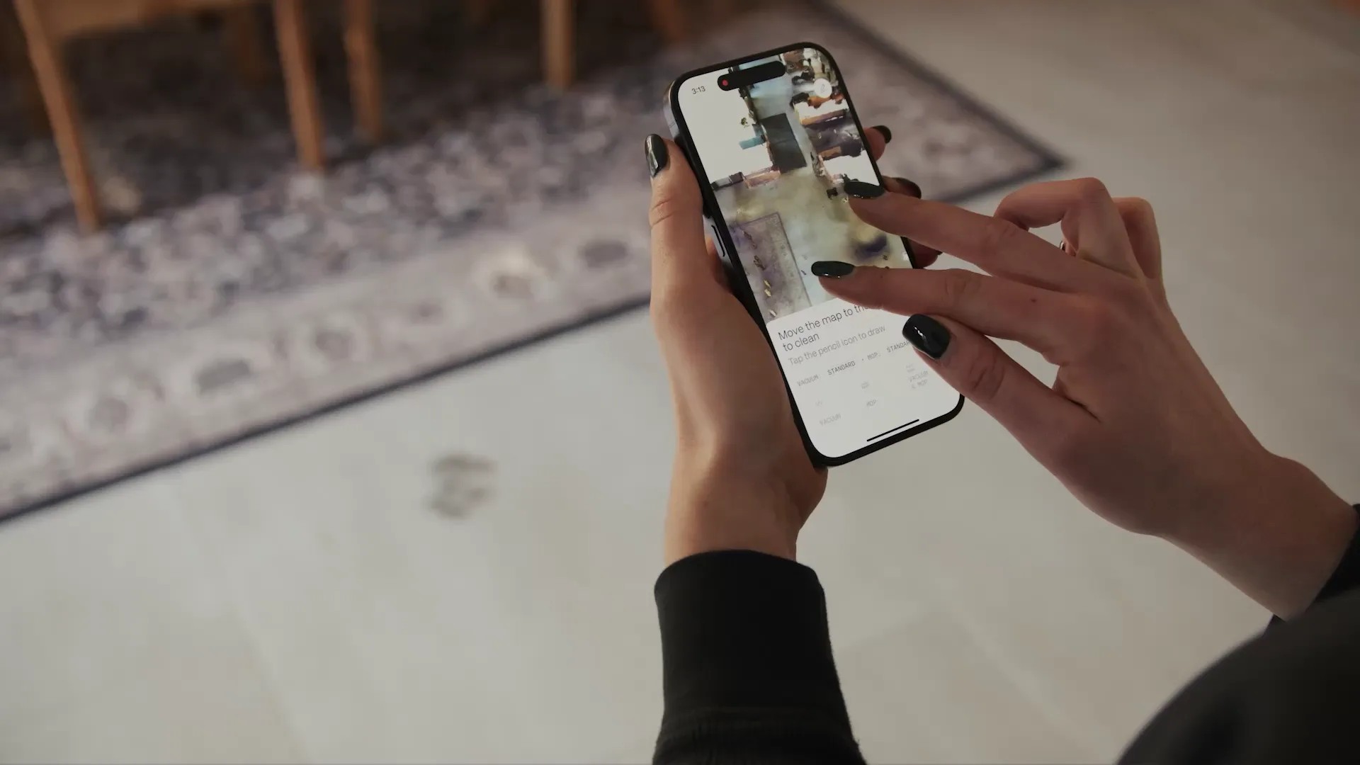 A person using the Matic app, drawing on a photo-realistic map of their floor to send the robot to a spot