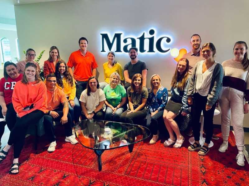 Matic employees gathered in the office beneath the company sign