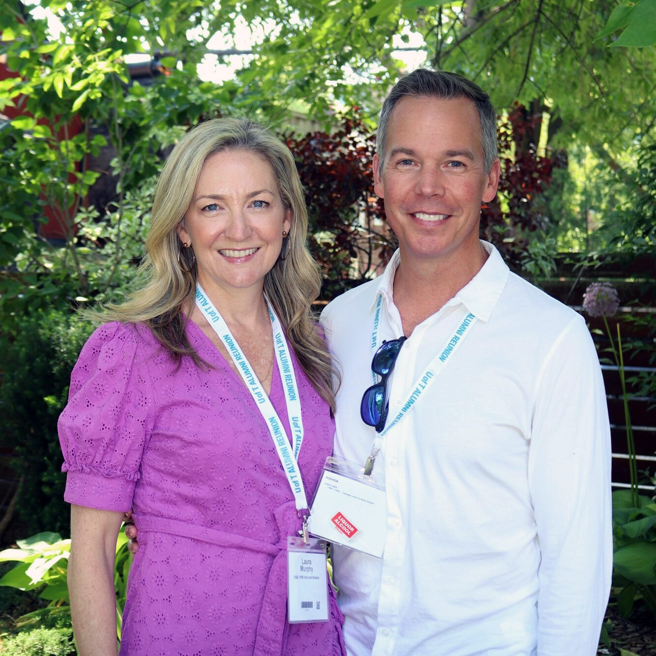 Laura Murphy and Matt Airhart at the 2023 Innis College alumni reunion, standing among leafy trees