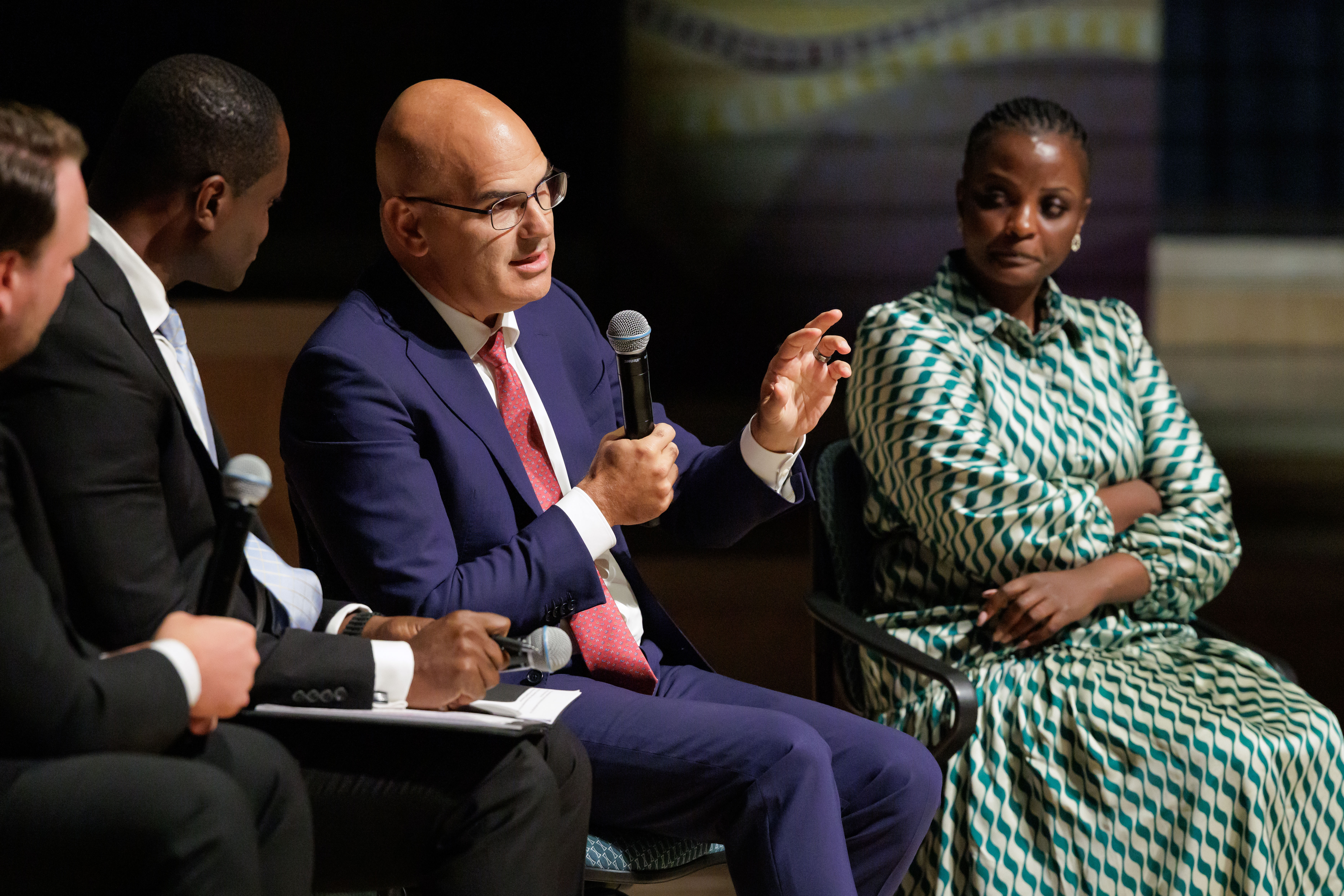 Matt Downs speaks into a microphone beside Grace Ninsiima during the Pathway to Hope panel.