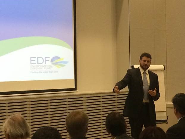 Matt Golden speaking beside an Environmental Defense Fund presentation screen at the Investor Confidence Project Europe launch in Brussels