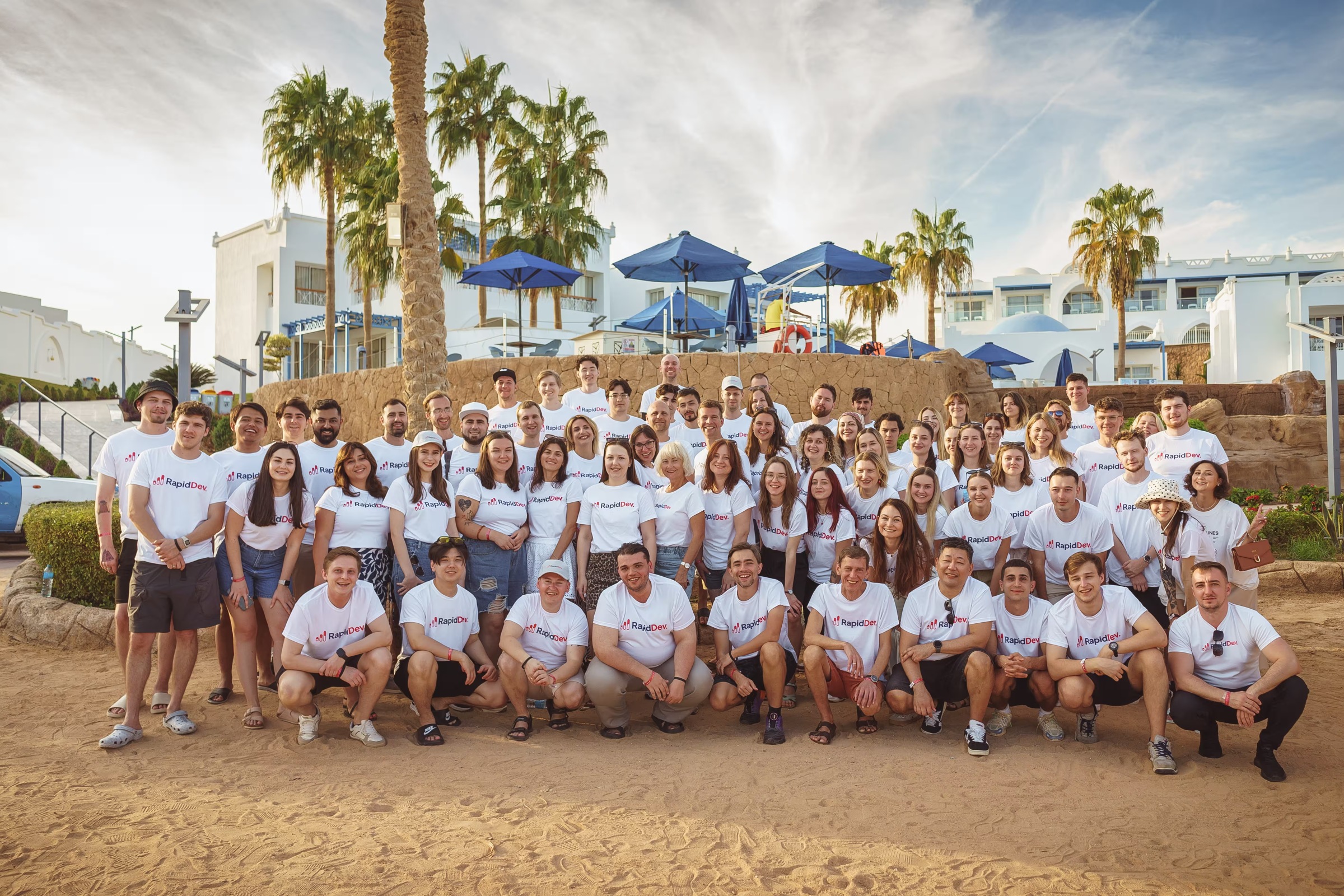 A large group of RapidDev colleagues gathered outdoors for a team photograph