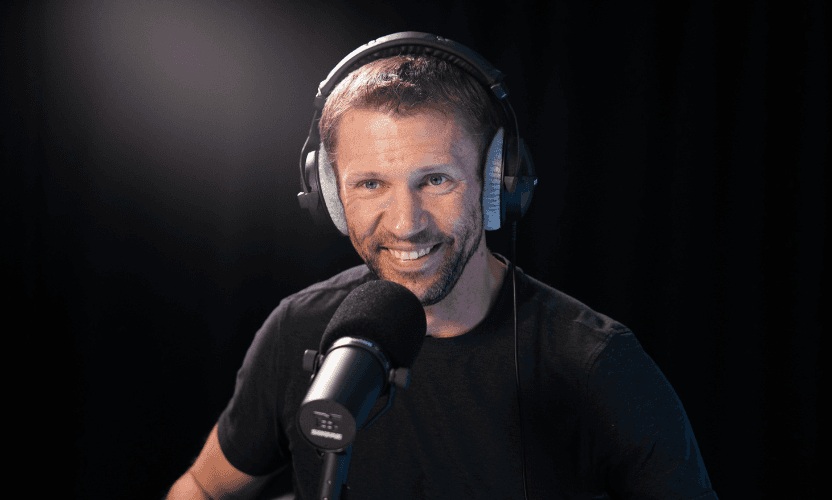 Matt Grimm speaking into a studio microphone during an interview