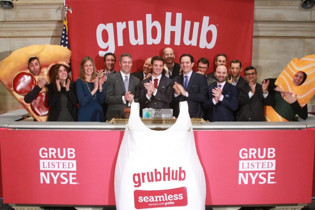 Matt Maloney and the Grubhub team applaud at the New York Stock Exchange, flanked by food costumes, April 4, 2014.