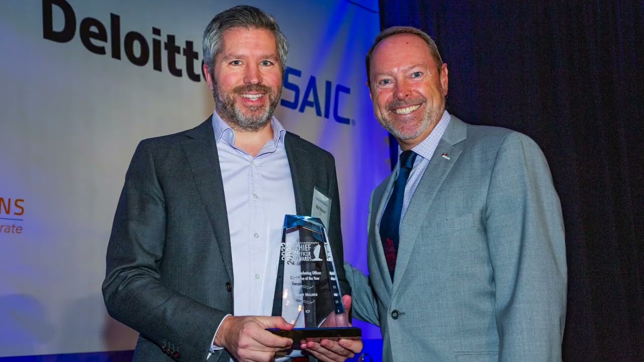 Matt Maurer holding his 2022 Chief Officer Award beside the award presenter