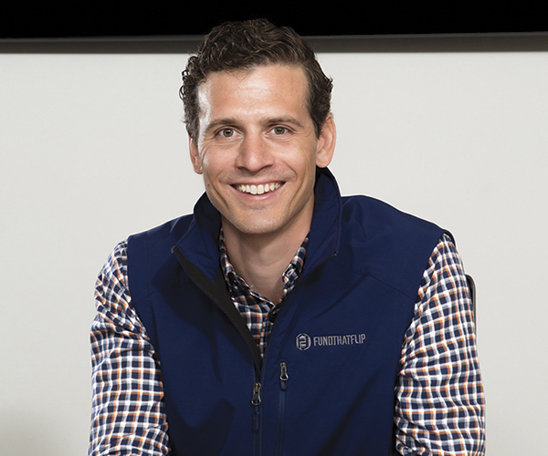 Matt Rodak seated in a Fund That Flip vest